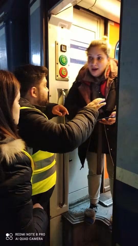 Ioan Caraian, în vestă de voluntar, oferind îndrumare unei persoane la coborârea din tren